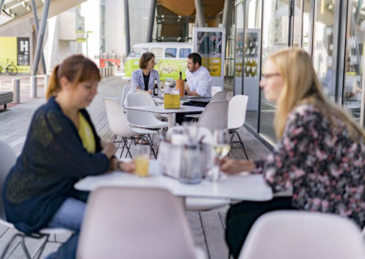 Menschen sitzen auf der Terrasse im Pan Pan